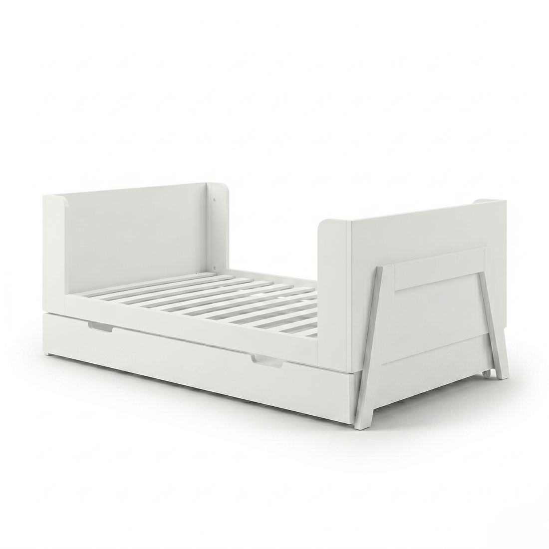 White toddler bed frame on white background angled view showing trundle drawer