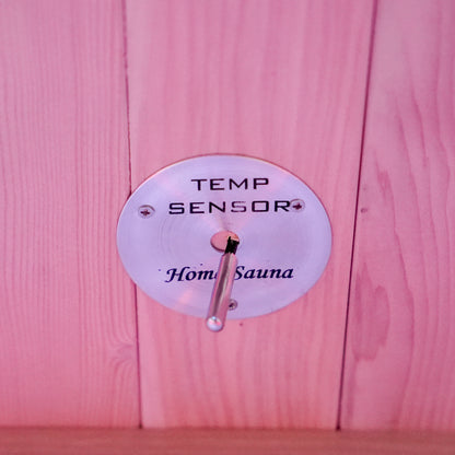Close-up of a temperature sensor mounted on a wooden sauna wall