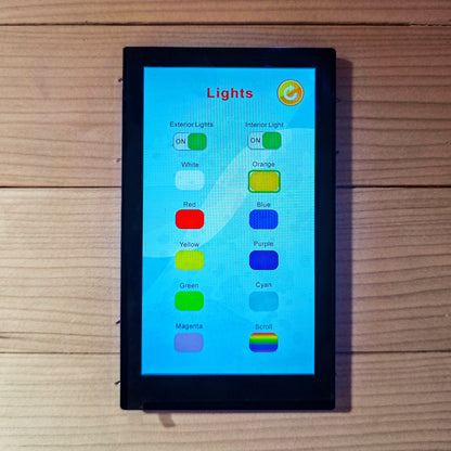 Touchscreen control panel mounted on a wood-paneled wall