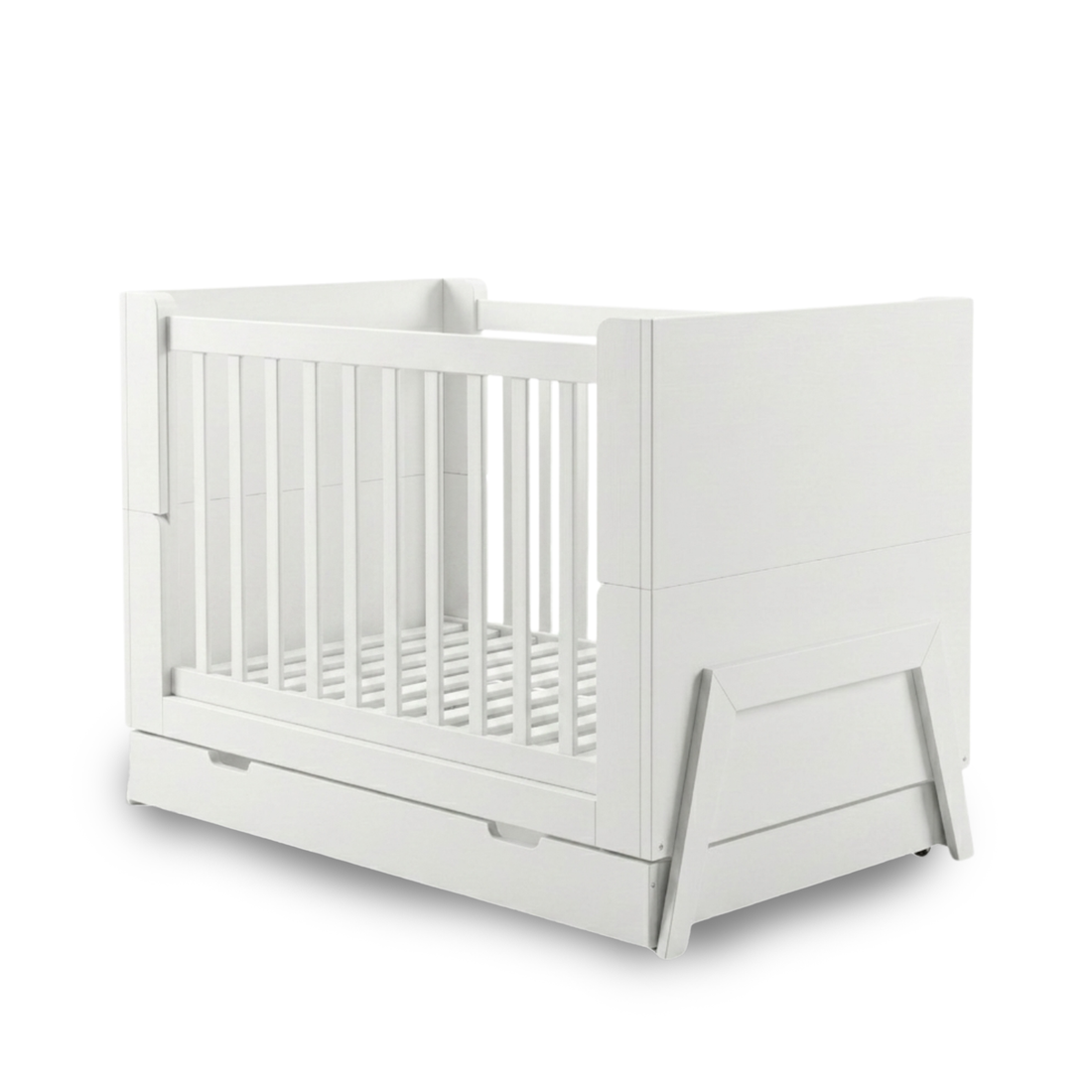 White baby crib on white background showing full product with solid panels, vertical slats, pull-out drawer and angled legs