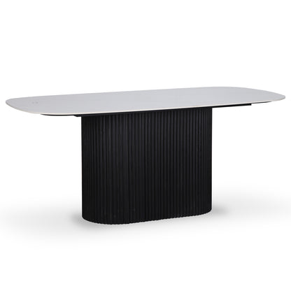 Aeris 180cm Marble Look Dining Table With Wood Base in Black features a white, rounded-rectangle tabletop and a black, vertically fluted pedestal base, showcasing a modern and elegant design.