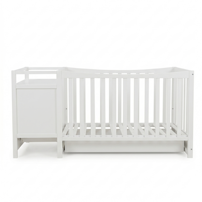 Side view of a white baby crib with attached storage unit on a white background