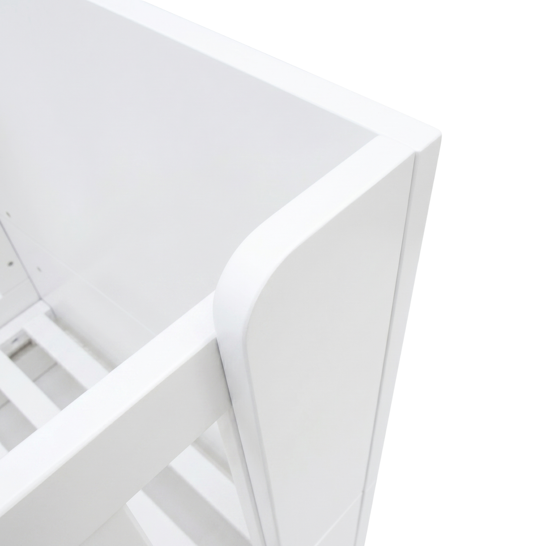 Close-up of white crib corner and slats on white background