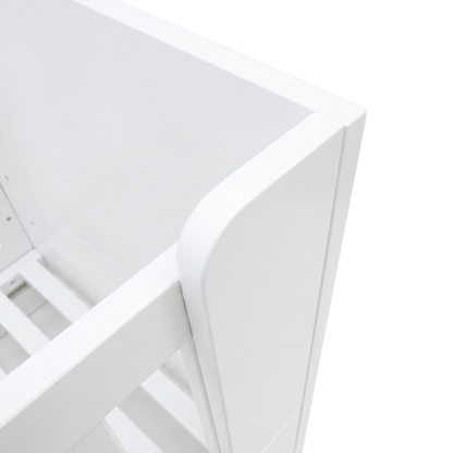 Close-up of white crib corner and slats on white background