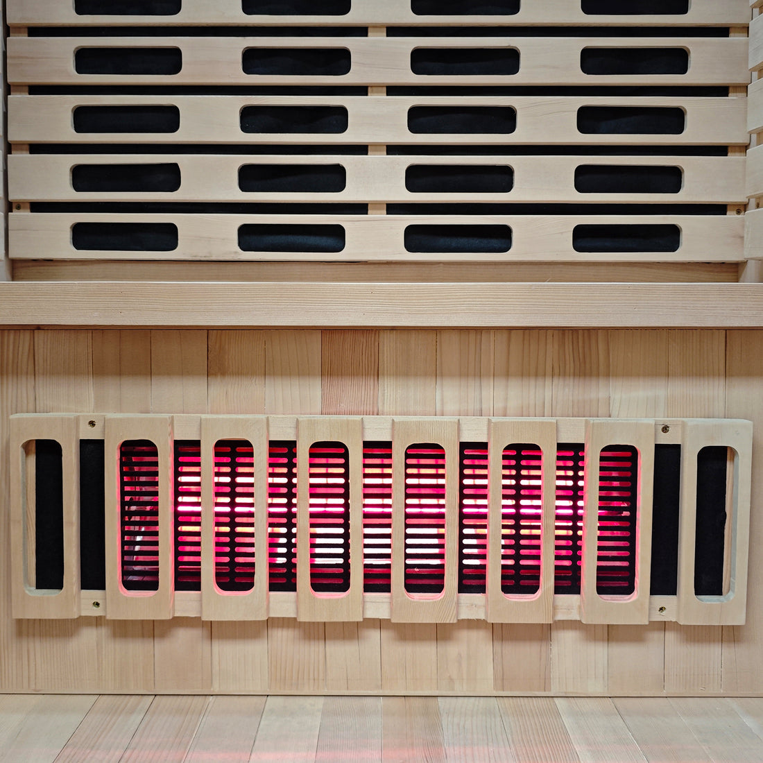 Close view of sauna interior wood slats and glowing heater element.