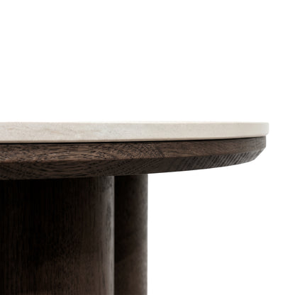 Close-up of the edge and structure of a round table with light top and dark wooden base