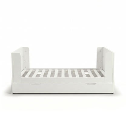 White toddler bed frame on white background with partial guard rails and trundle drawer