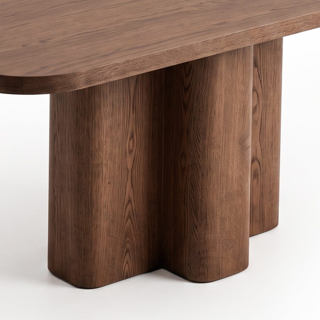 Close-up of a wooden furniture piece with rounded legs and smooth top on white background.
