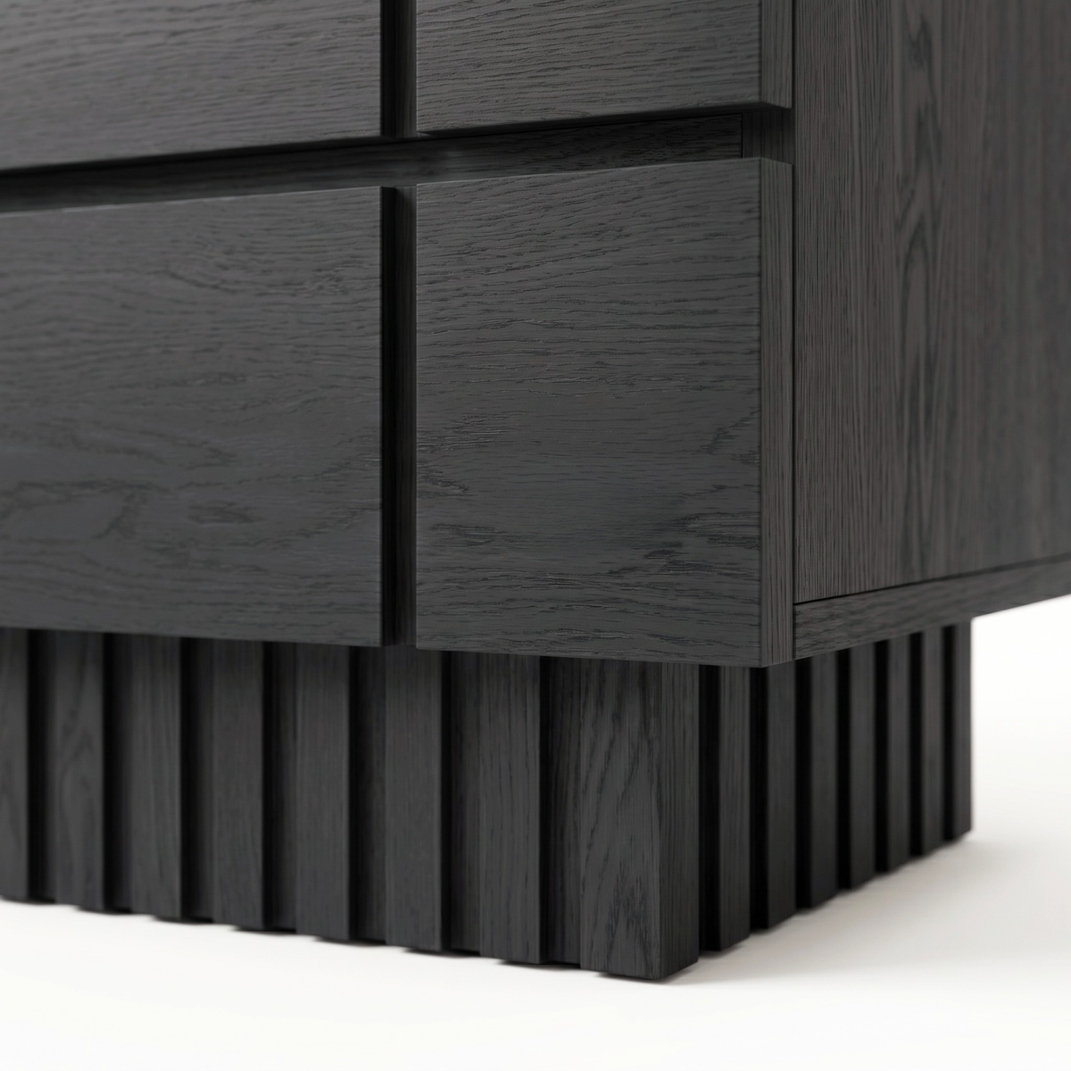 Close-up of the lower corner and textured base of a black wooden nightstand