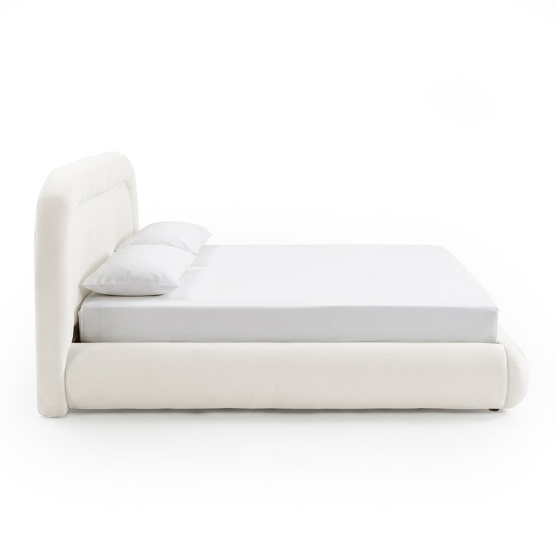 Side view of modern upholstered bed with pillows on white background