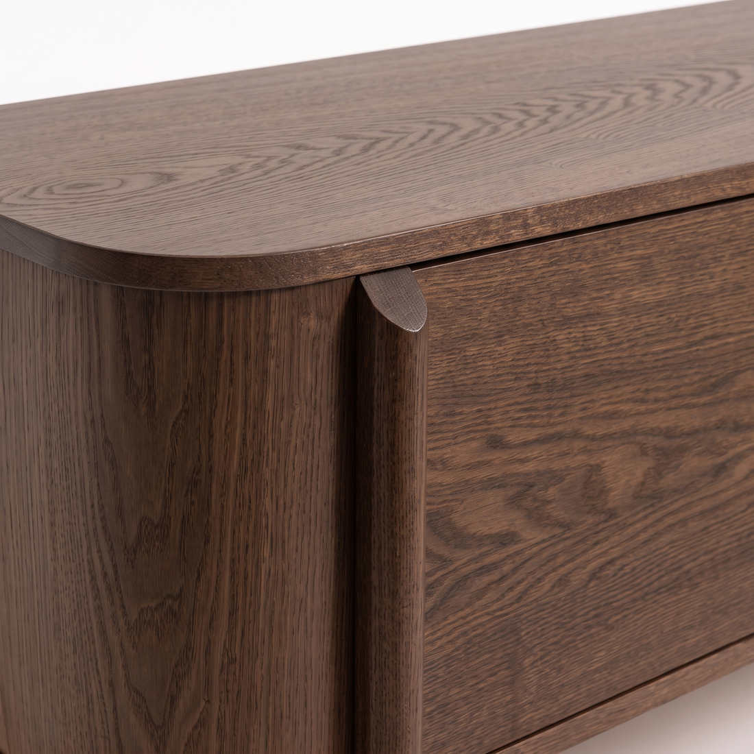 Close-up of a dark wood furniture corner and side on a white background.