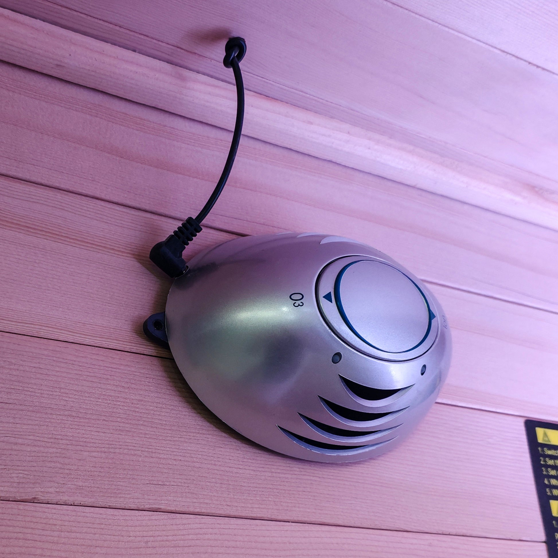 Small metallic dome-shaped device on wooden planks