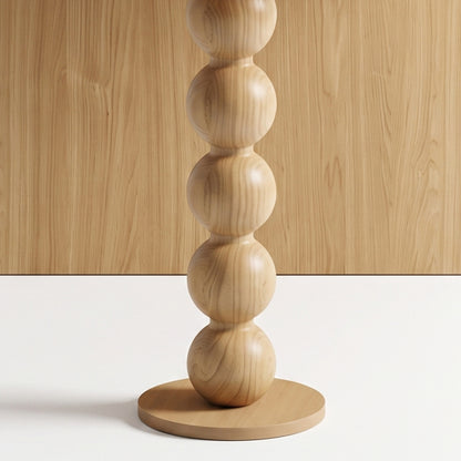 Close-up of a sculptural wooden object with stacked spherical segments on a base