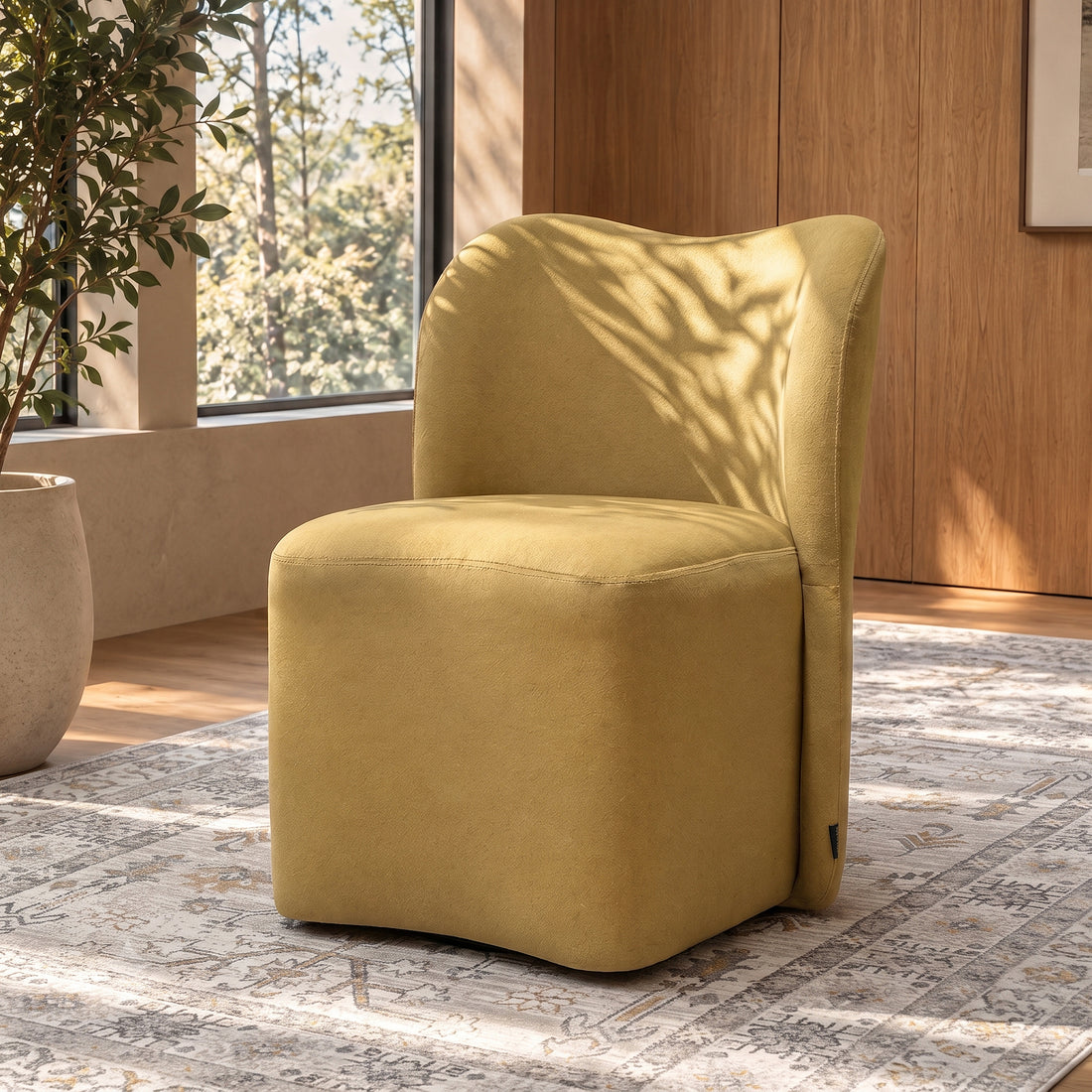 Mustard yellow upholstered chair in a stylish sunlit room with rug and plant