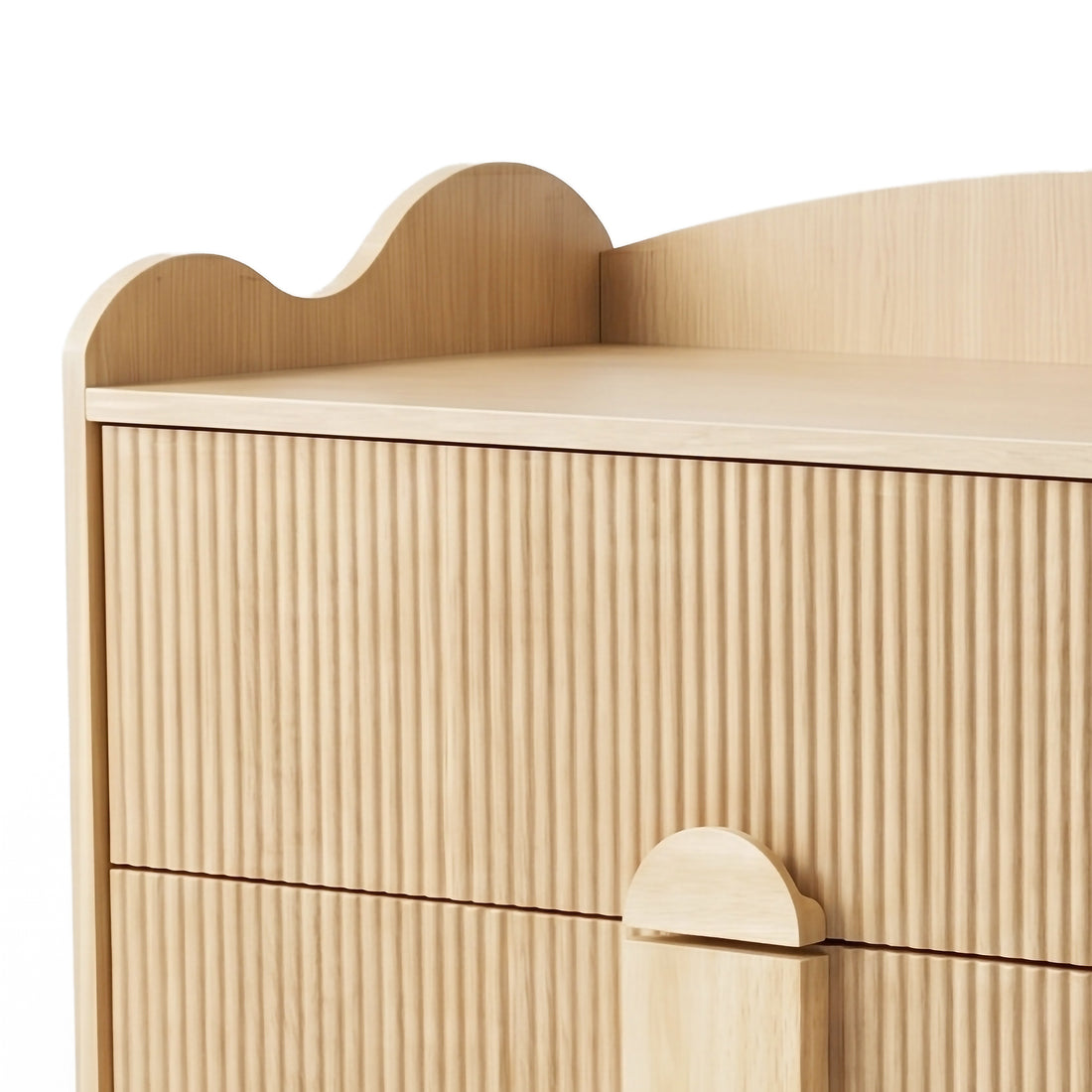 Upper section of wood dresser showing fluted drawer fronts and scalloped top edge