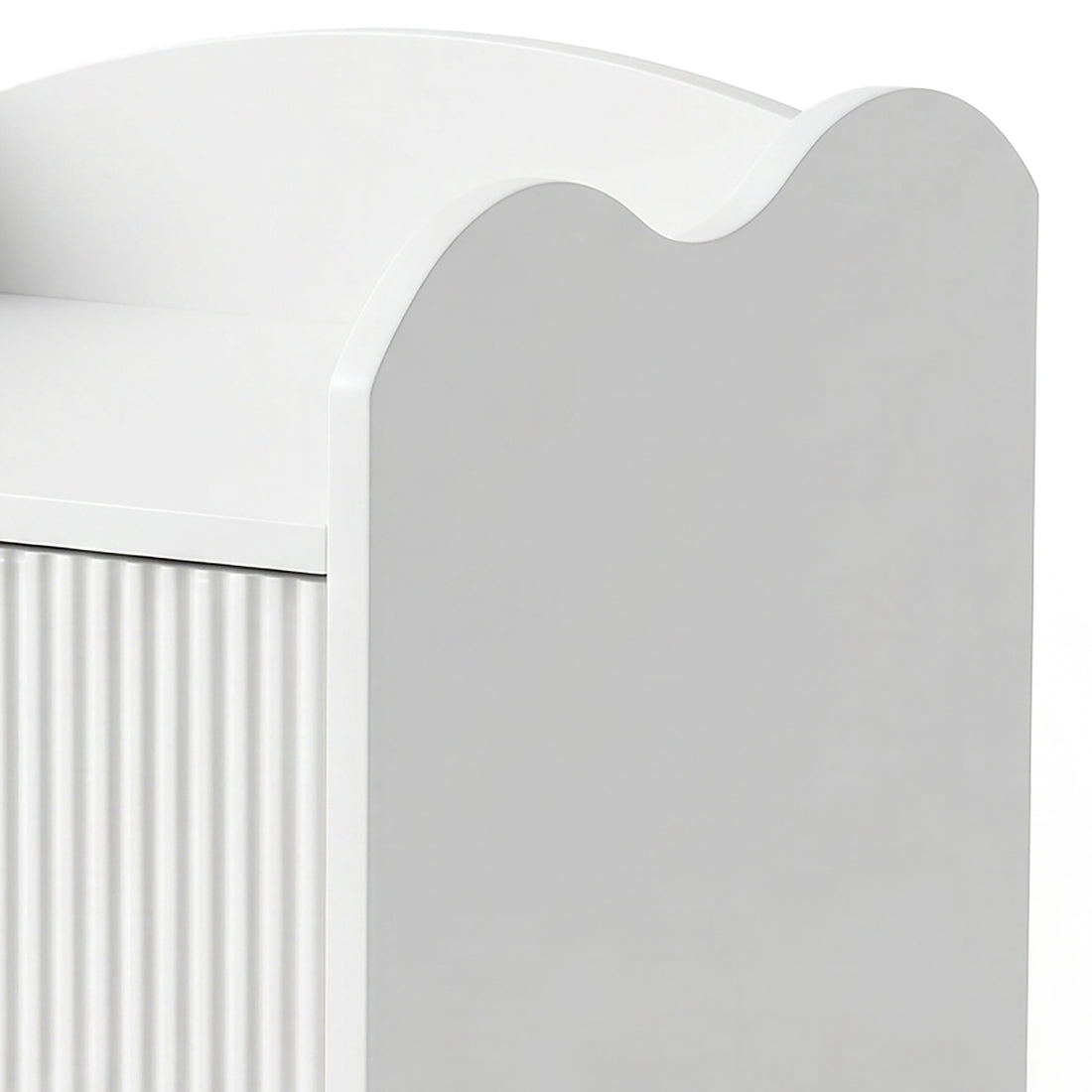Partial view of white furniture with ribbed side panel and curved top edge on white background