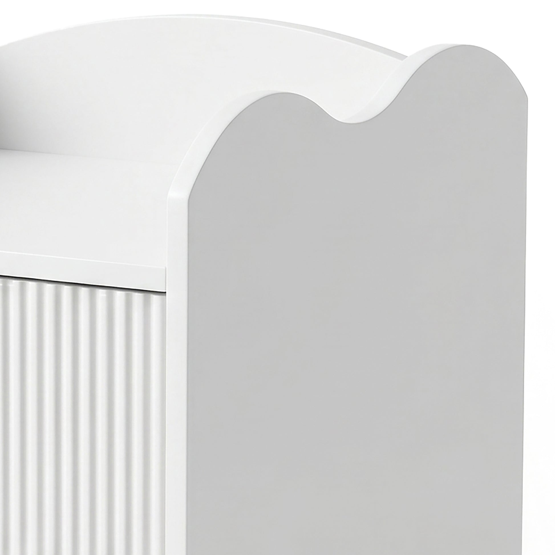 Partial view of white furniture with ribbed side panel and curved top edge on white background