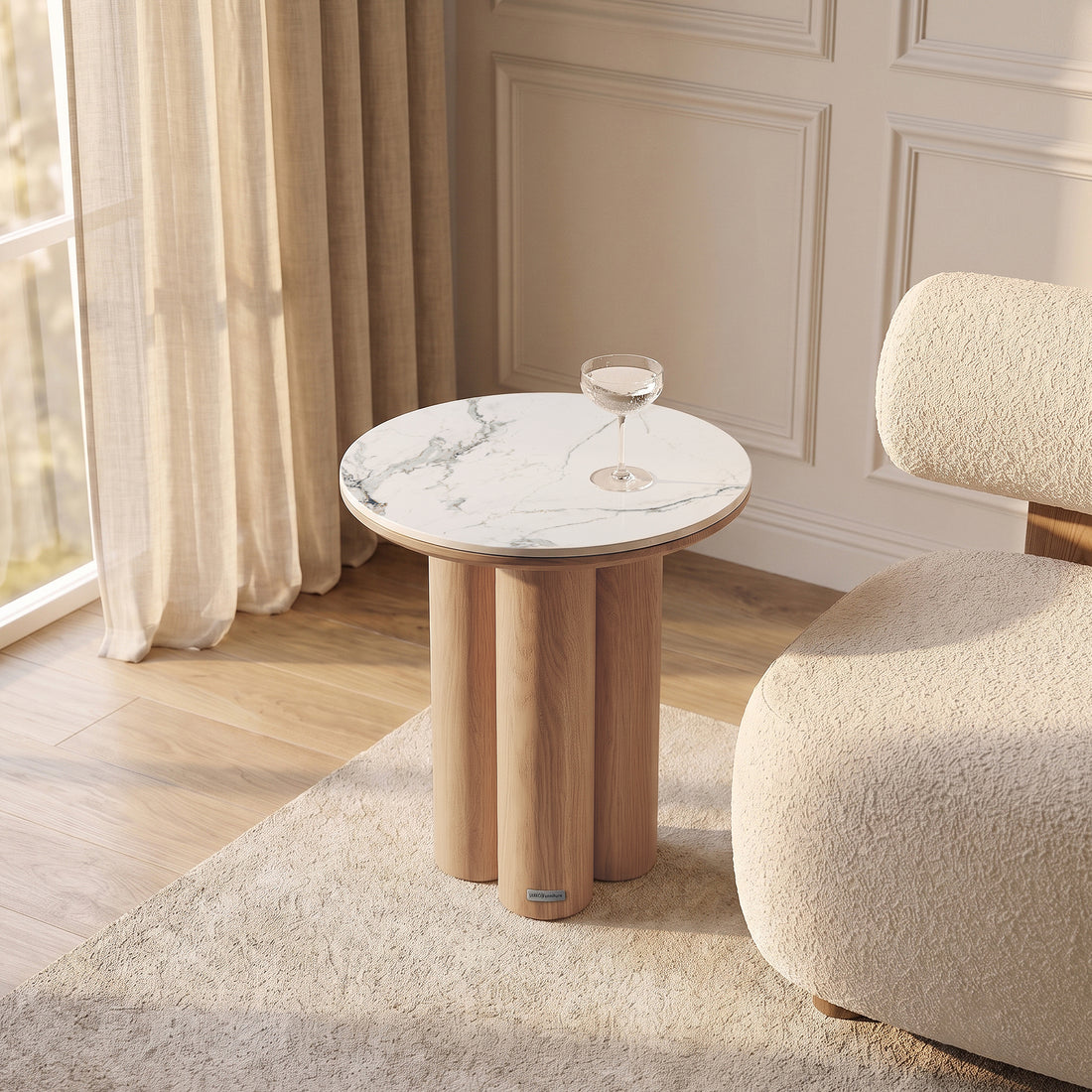 Modern round side table styled in a bright room with chair and curtains