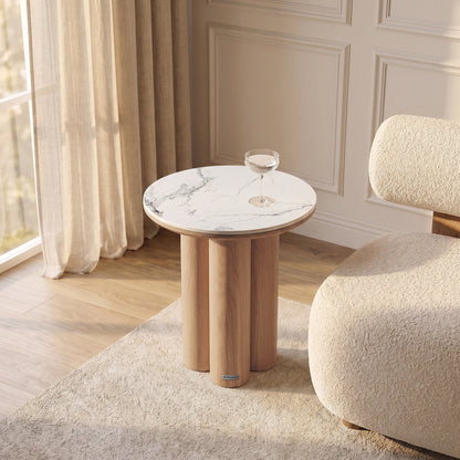 Modern round side table styled in a bright room with chair and curtains