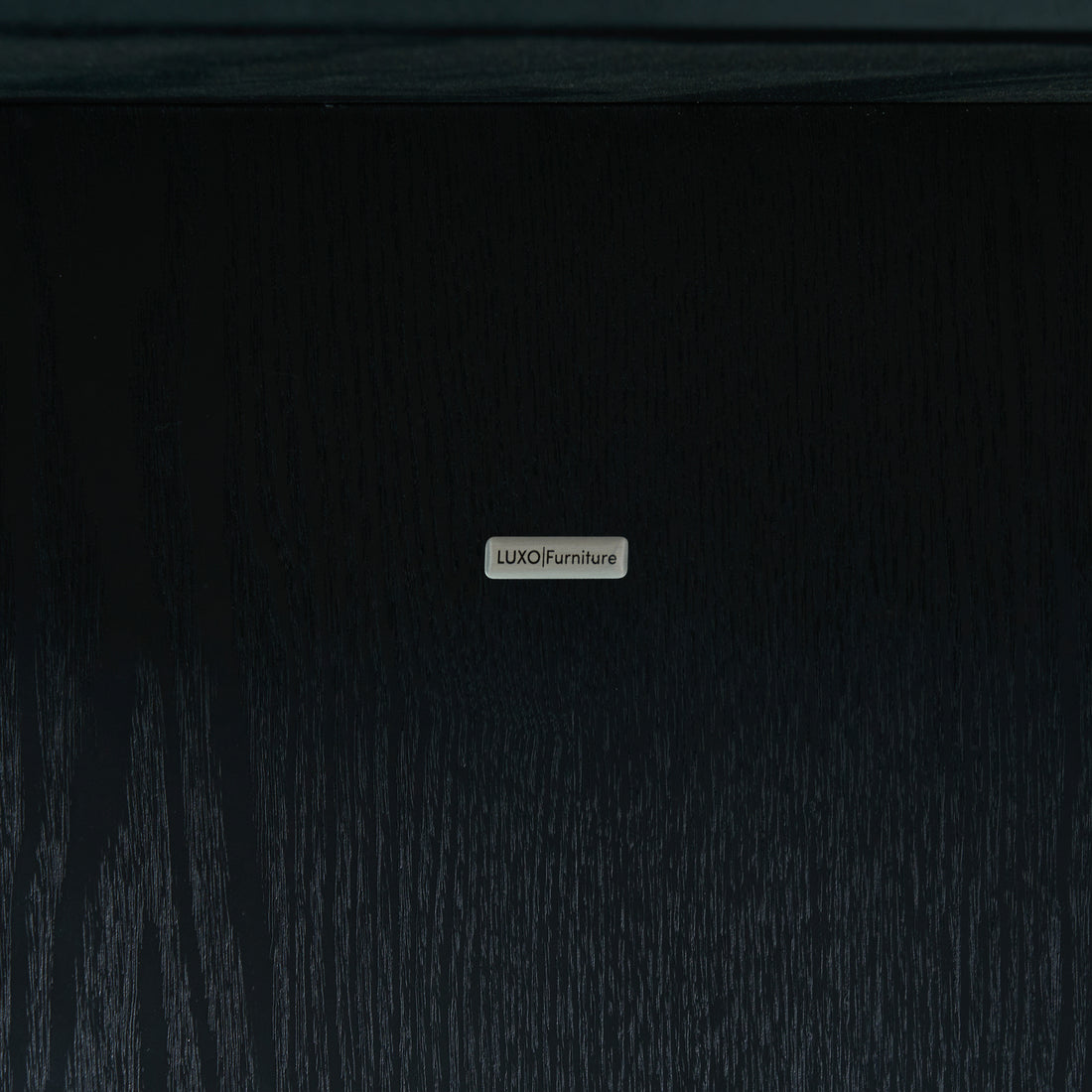 Close-up of branded metal nameplate on dark wood surface