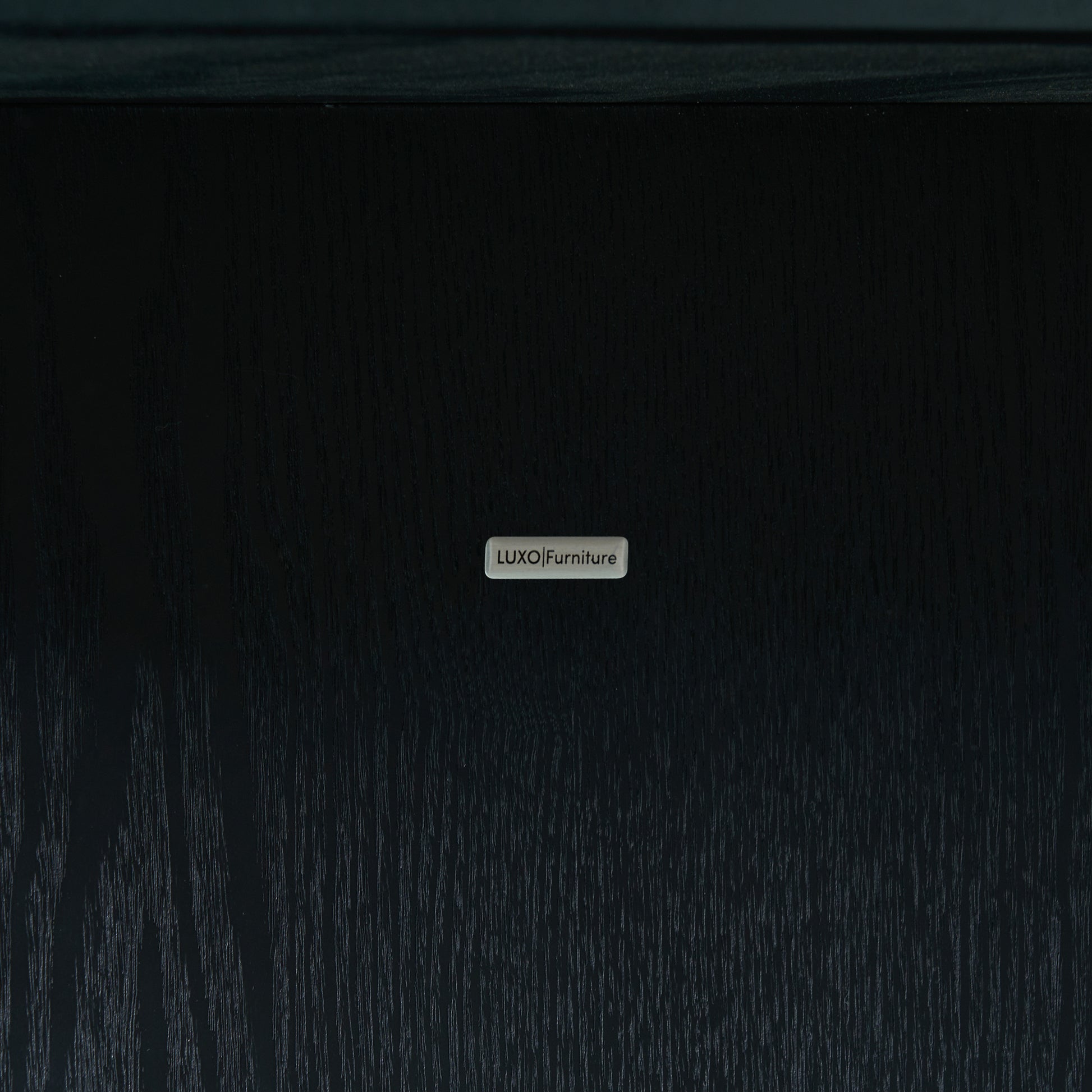 Close-up of branded metal nameplate on dark wood surface