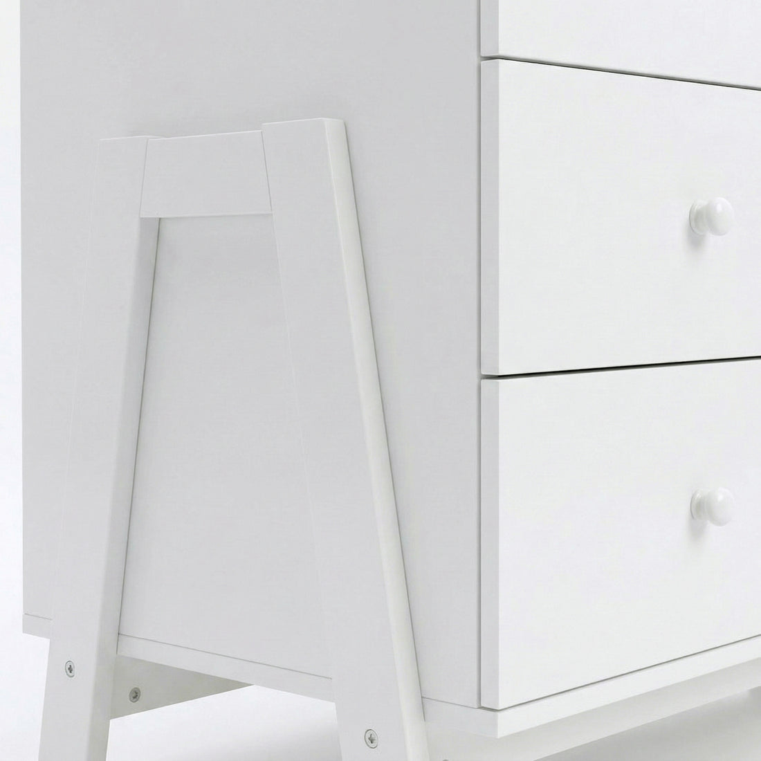 Close-up of bottom corner and drawer fronts of white dresser