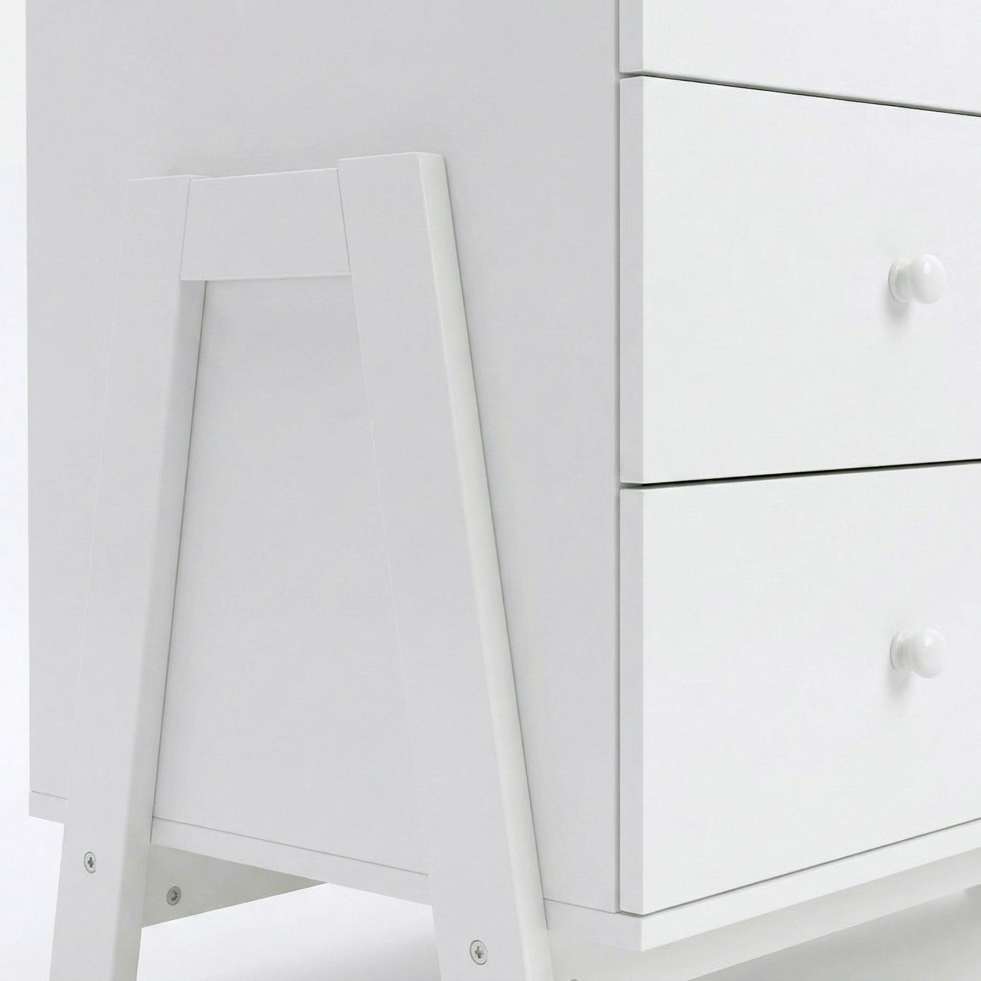 Close-up of bottom corner and drawer fronts of white dresser