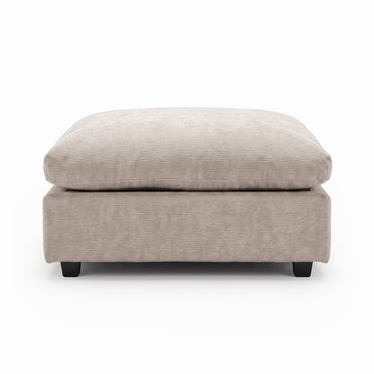 Beige upholstered ottoman with plush cushion on a white background.