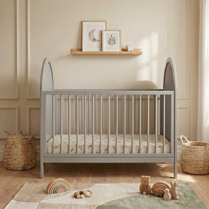 Modern grey crib in nursery with toys and wall decor