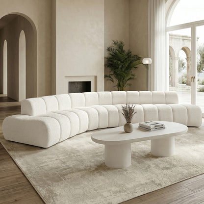 White curved sectional sofa in a modern living room with coffee table and décor