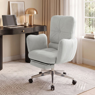Light gray upholstered office chair styled in a bright home office with desk, lamp, and decor