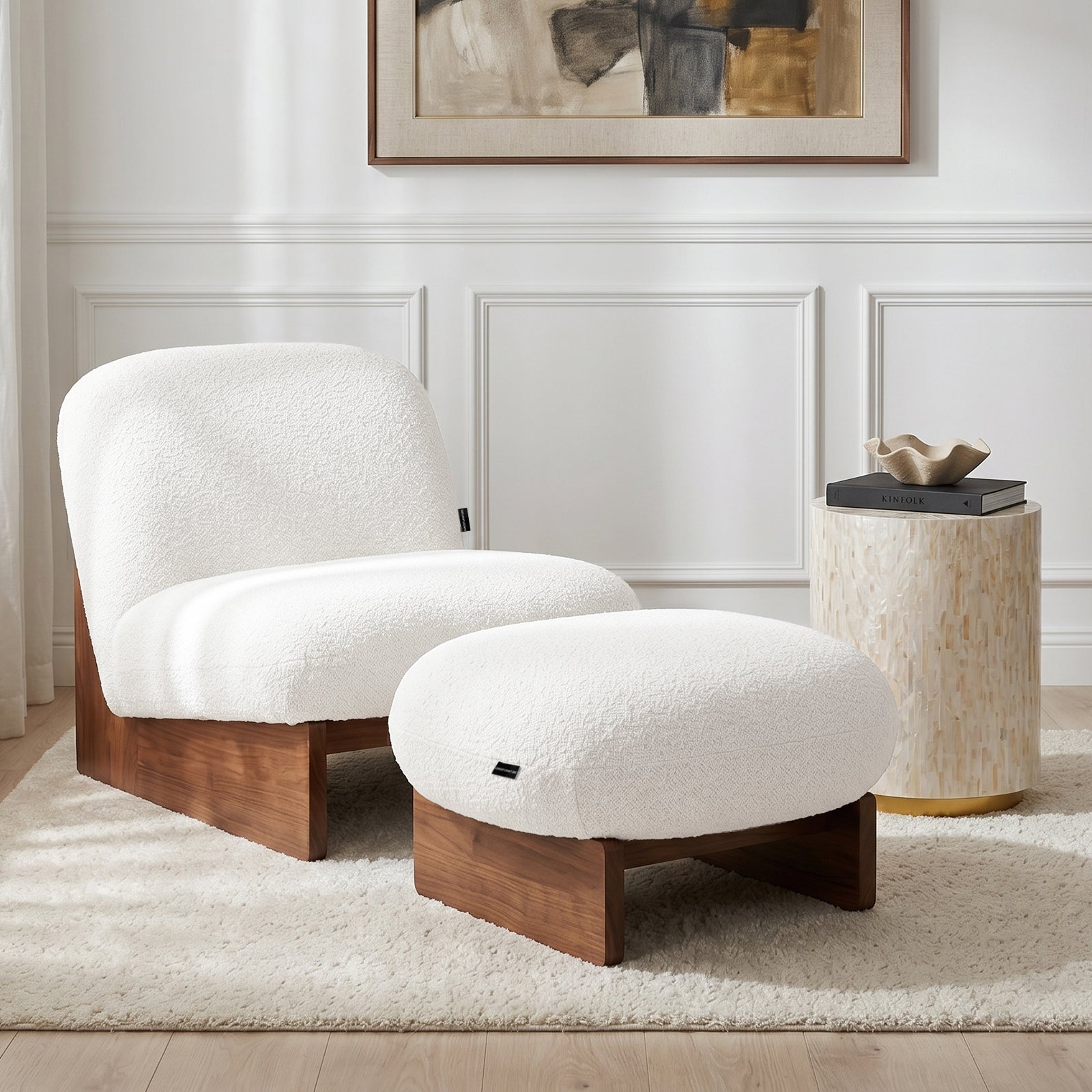 Modern lounge chair and ottoman set in a styled living room with abstract artwork and side table.