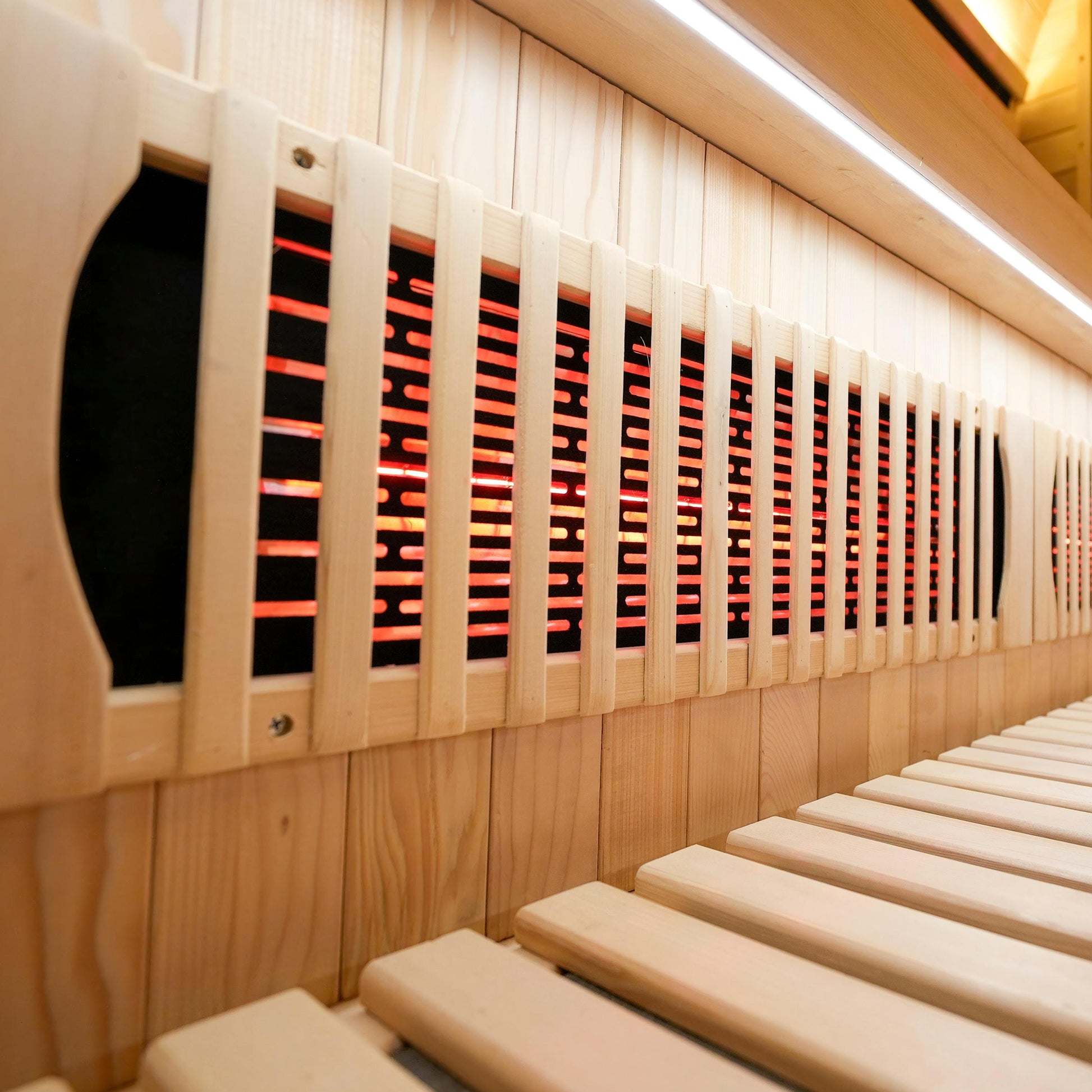 Side view of wooden sauna interior with bench and infrared heating panels