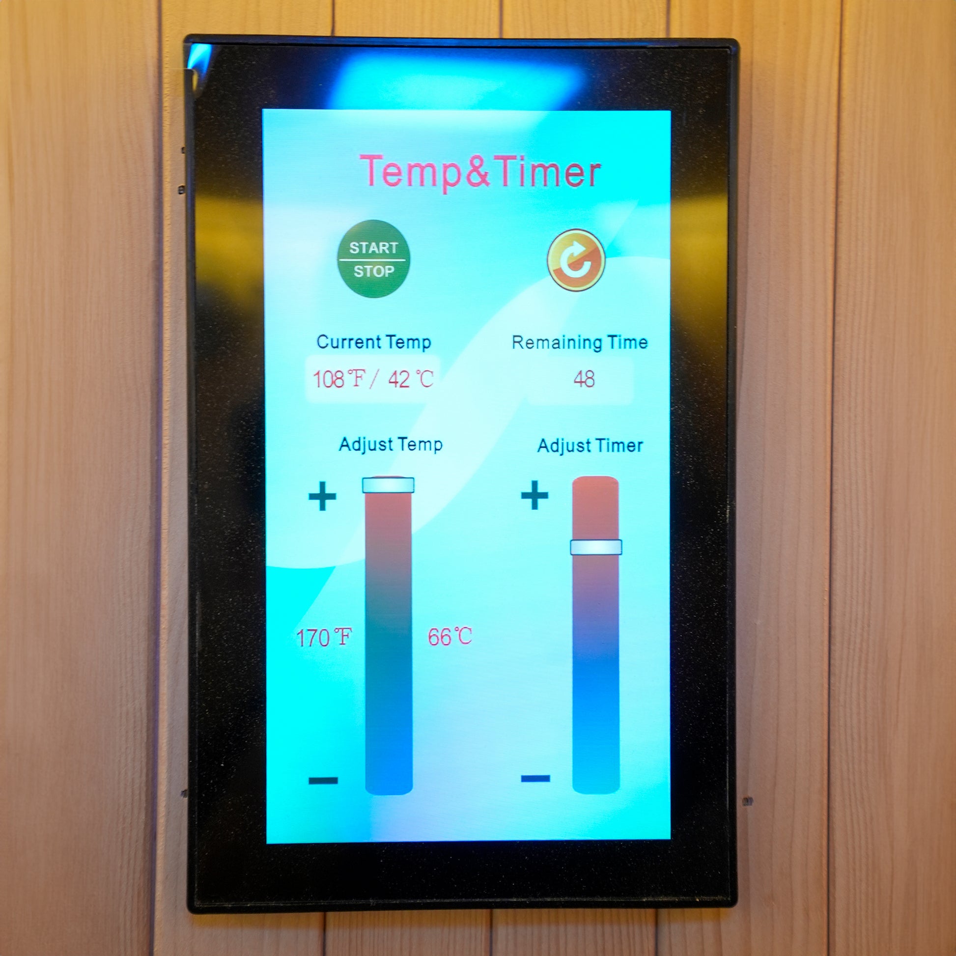Touchscreen sauna control panel mounted on a wooden wall
