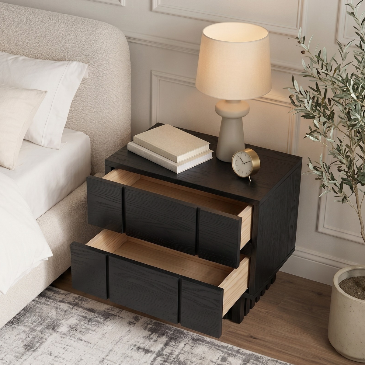 Black nightstand next to a bed in a styled bedroom