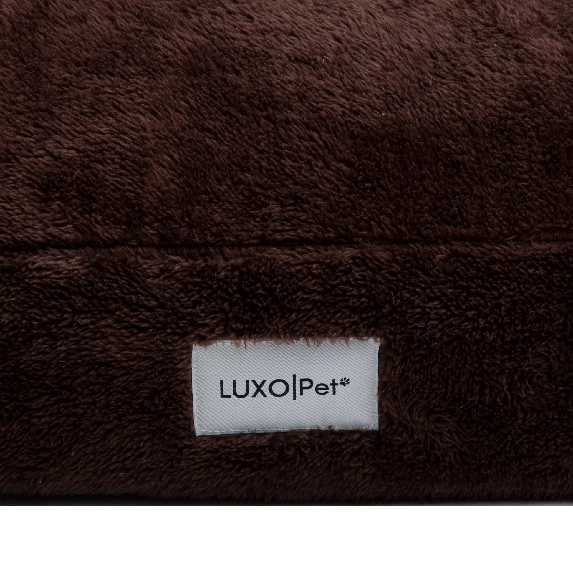 Close-up of plush brown fabric seam and Luxo|Pet label on white background