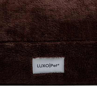 Close-up of plush brown fabric seam and Luxo|Pet label on white background