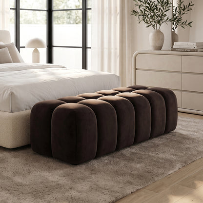 Chocolate brown tufted ottoman bench placed at the foot of a bed in a bedroom.