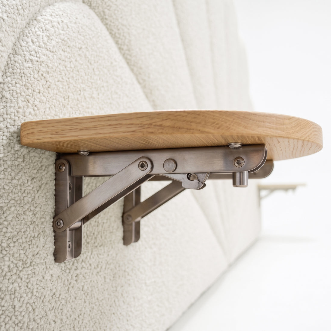 Close-up of foldable wooden tray mounted on upholstered wall panel