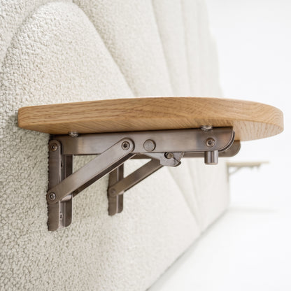 Close-up of foldable wooden tray mounted on upholstered wall panel