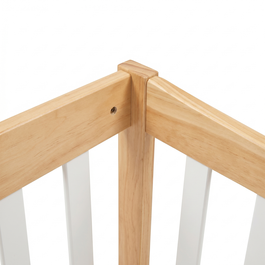 Close-up of a wooden crib corner with white slats