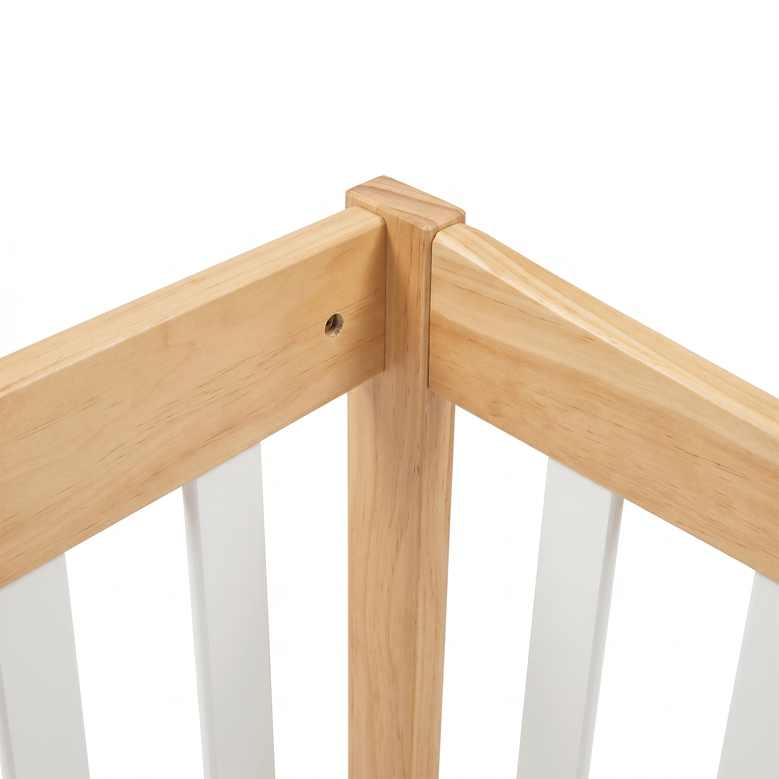 Close-up of a wooden crib corner with white slats
