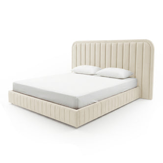 Cream upholstered bed frame with mattress and pillows on white background