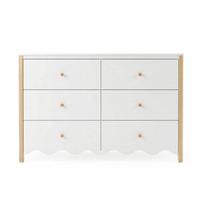 Front view of white six-drawer dresser with scalloped edge and wood accents on white background