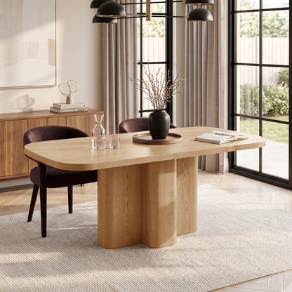 Wooden dining table staged in a modern dining room with chairs and decor