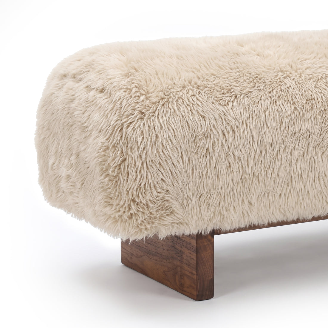Cream faux fur ottoman or bench on white background, slightly cropped