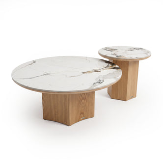 Two round nested tables with white marble tops and light wood bases on a white background.