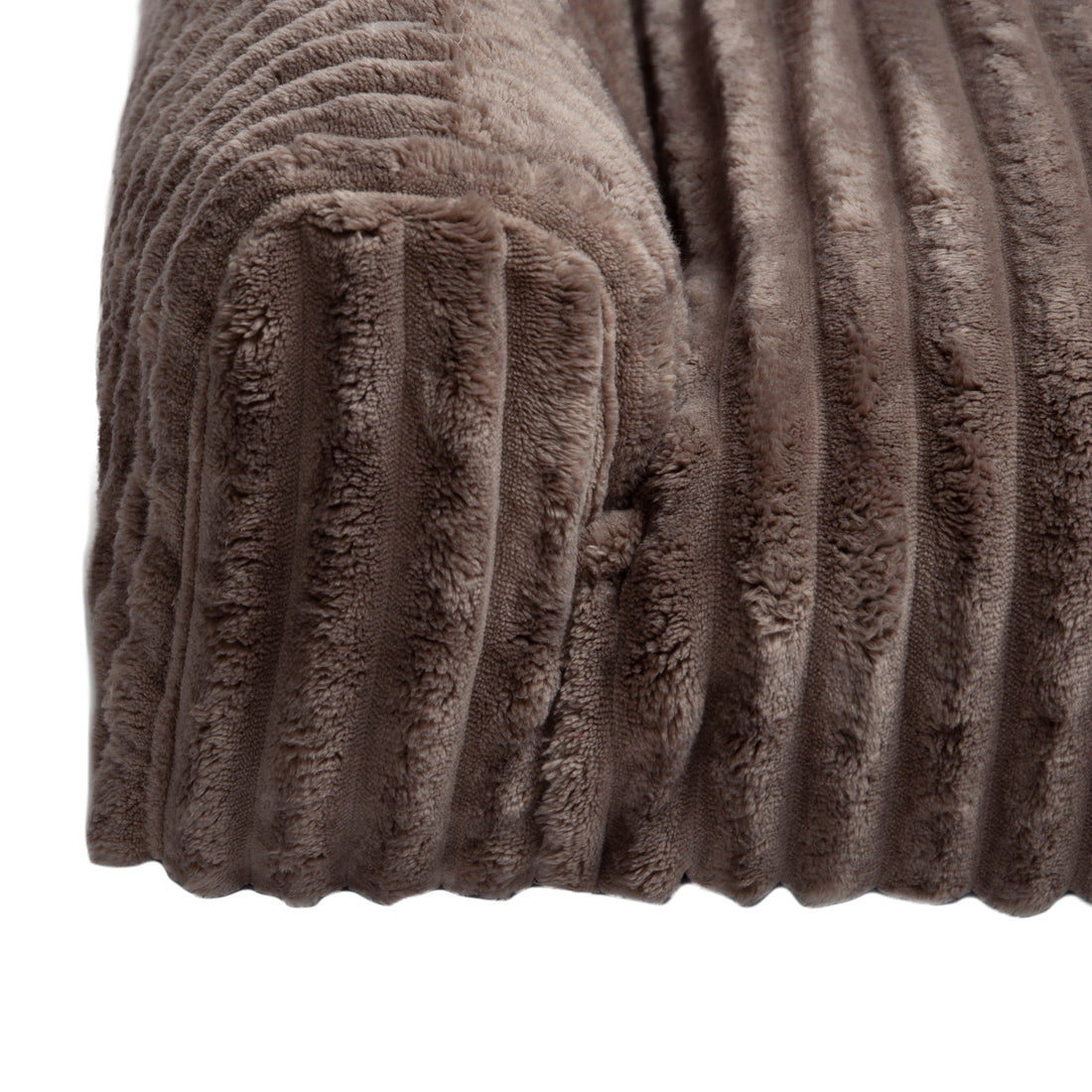 Close-up of plush ribbed brown fabric corner on white background