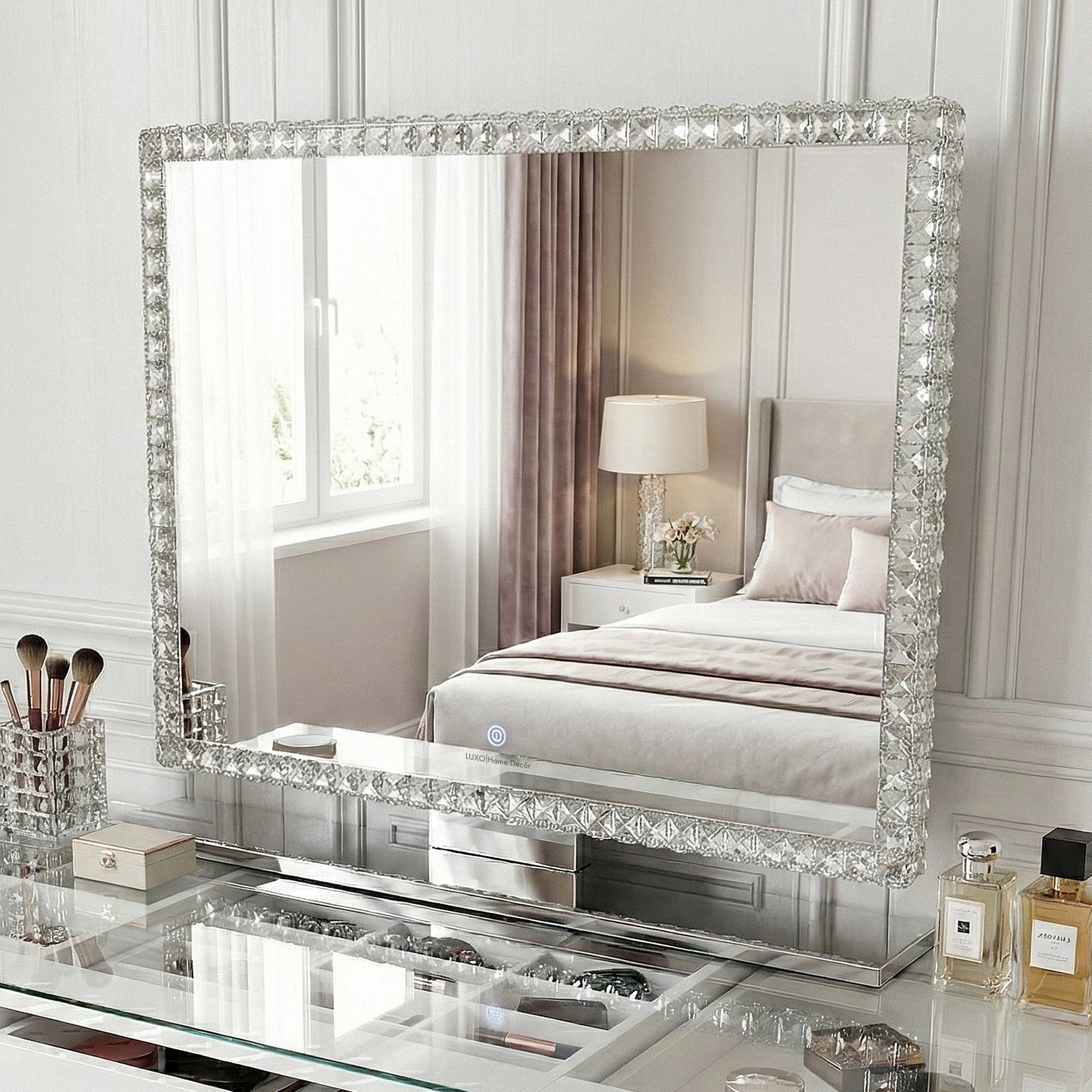Ornate crystal-studded wall mirror above a glass vanity in a bedroom