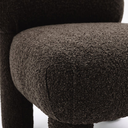 Close-up of dark brown boucle fabric and cushion edge of chair